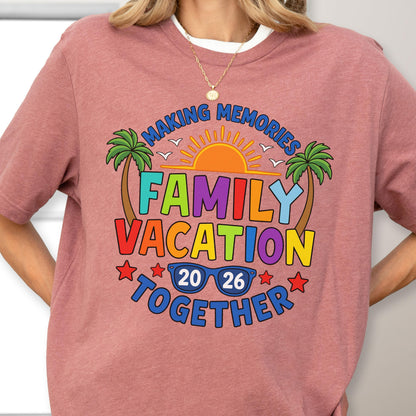 May include: A dusty rose t-shirt featuring a colorful graphic with the text "MAKING MEMORIES FAMILY VACATION TOGETHER" and "20 26". The design includes a bright orange sun, two green palm trees, white birds, and blue sunglasses, all accented by small red stars.