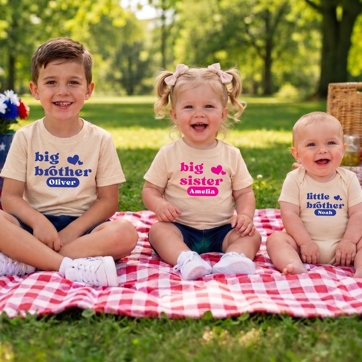 May include: Three beige shirts and a onesie featuring blue and pink text. The first shirt says big brother Oliver, the second says big sister Amelia, and the third says little brother Noah. Each garment includes a small heart graphic.