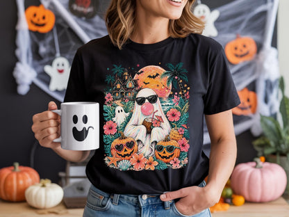 May include: A black t-shirt featuring a graphic of a ghost wearing sunglasses and blowing a pink bubble, holding a coconut drink. The design includes a haunted house, palm trees, a full moon, bats, and two jack-o'-lanterns with sunglasses.
