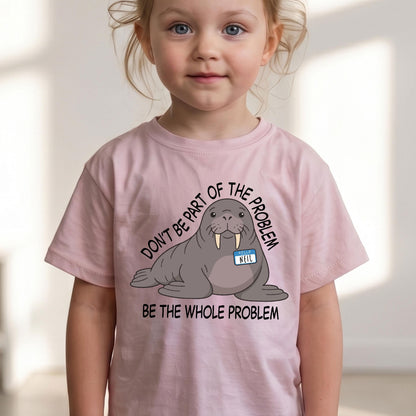 May include: A light pink short-sleeved t-shirt featuring a graphic of a grey walrus wearing a blue name tag that says NEIL. The text surrounding the walrus reads DON'T BE PART OF THE PROBLEM BE THE WHOLE PROBLEM in black capital letters.