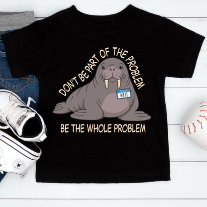 May include: A black t-shirt featuring a cartoon walrus with a name tag that reads "HELLO NEIL". The text above the walrus says "DON'T BE PART OF THE PROBLEM" and the text below the walrus says "BE THE WHOLE PROBLEM" in a light beige font.