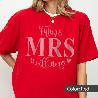 May include: A bright red short-sleeved t-shirt featuring the text Future MRS Williams in a combination of script and bold serif fonts. A small heart icon is positioned to the right of the name. The shirt has a crew neckline and a relaxed fit.