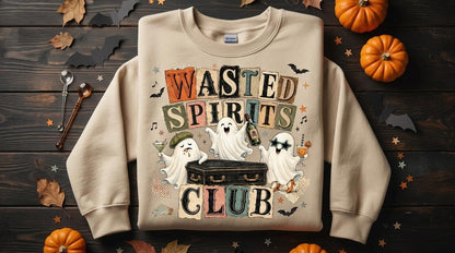 May include: A beige crewneck sweatshirt featuring a graphic print with the text "WASTED SPIRITS CLUB" in block letters. The design includes three white ghosts, one holding a martini glass, one holding a bottle, and one wearing star-shaped glasses, all positioned around a black coffin.