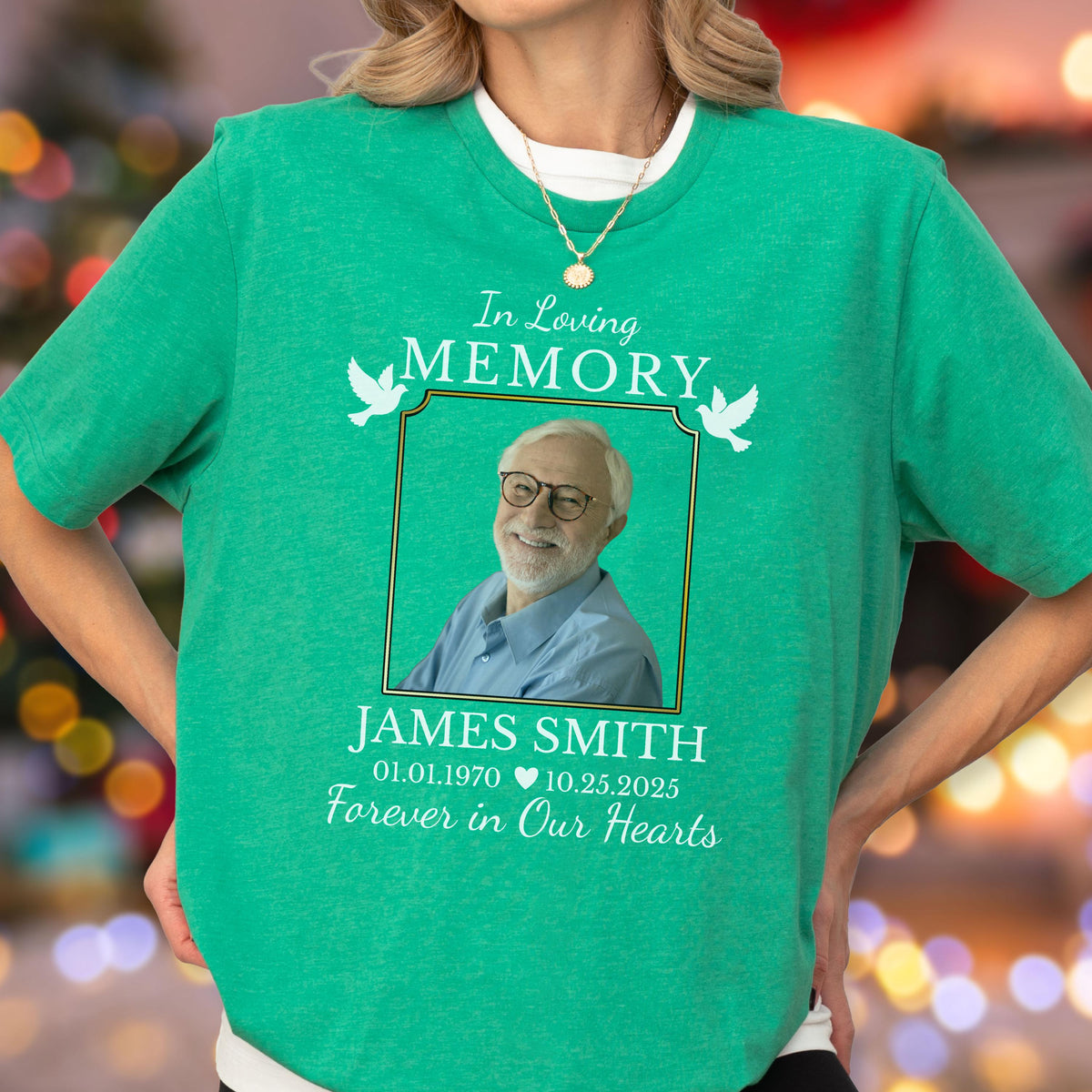 May include: A bright green short-sleeve t-shirt featuring a memorial graphic with the text In Loving Memory, James Smith, 01.01.1970, 10.25.2025, and Forever in Our Hearts. The design includes a photo of a smiling man with glasses and two white doves.