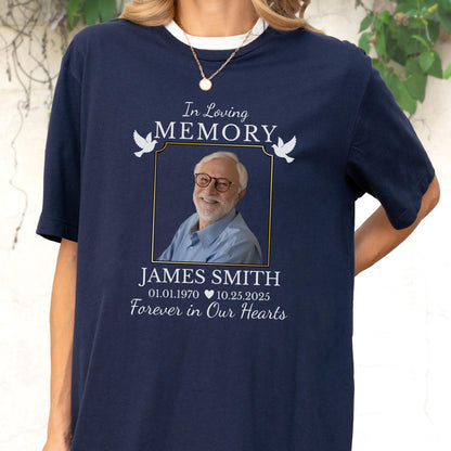 May include: A navy blue t-shirt featuring a memorial graphic with the text In Loving Memory, a photograph of a man wearing glasses, the name James Smith, the dates 01.01.1970 and 10.25.2025, a heart icon, and the phrase Forever in Our Hearts.