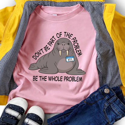 May include: A light pink t-shirt featuring a graphic illustration of a grey walrus wearing a blue name tag that says "HELLO NEIL". The text "DON'T BE PART OF THE PROBLEM" is arched above the walrus, and "BE THE WHOLE PROBLEM" is printed below.