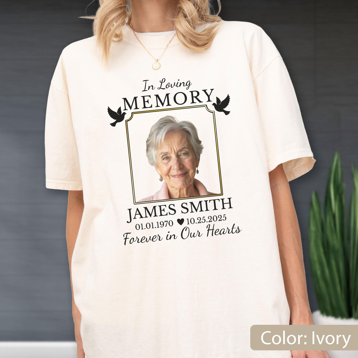 May include: An ivory t-shirt featuring a memorial graphic with the text In Loving MEMORY, a framed photograph of an older person, the name JAMES SMITH, the dates 01.01.1970 and 10.25.2025 separated by a heart, and the phrase Forever in Our Hearts.