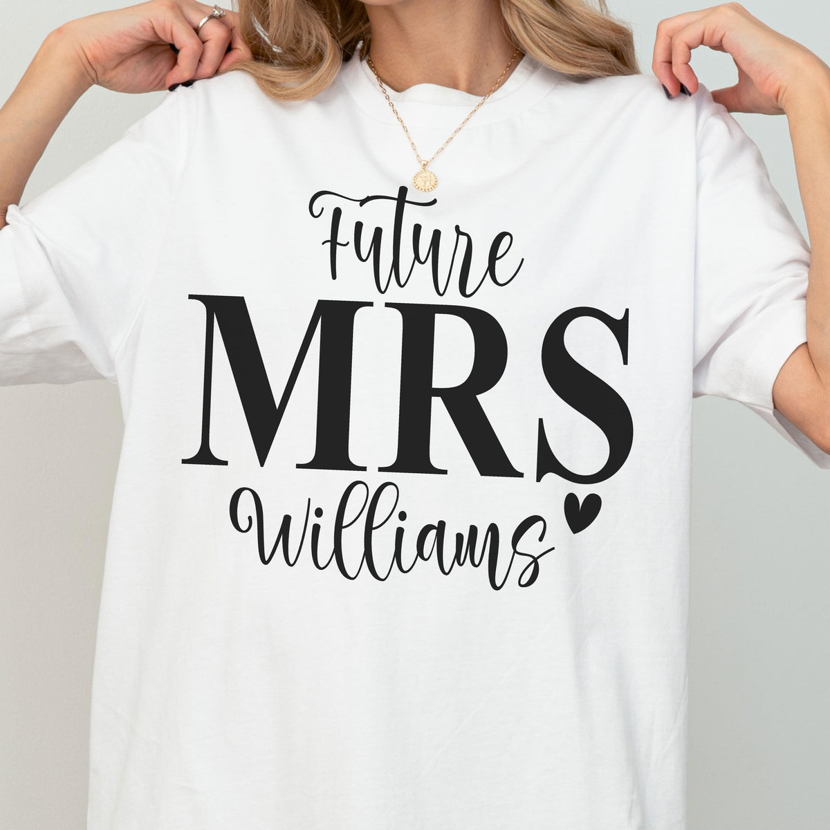 May include: A white short-sleeved t-shirt featuring black text that reads Future MRS Williams with a small black heart icon. The design is centered on the chest area of the garment, utilizing a combination of script and bold serif typography.