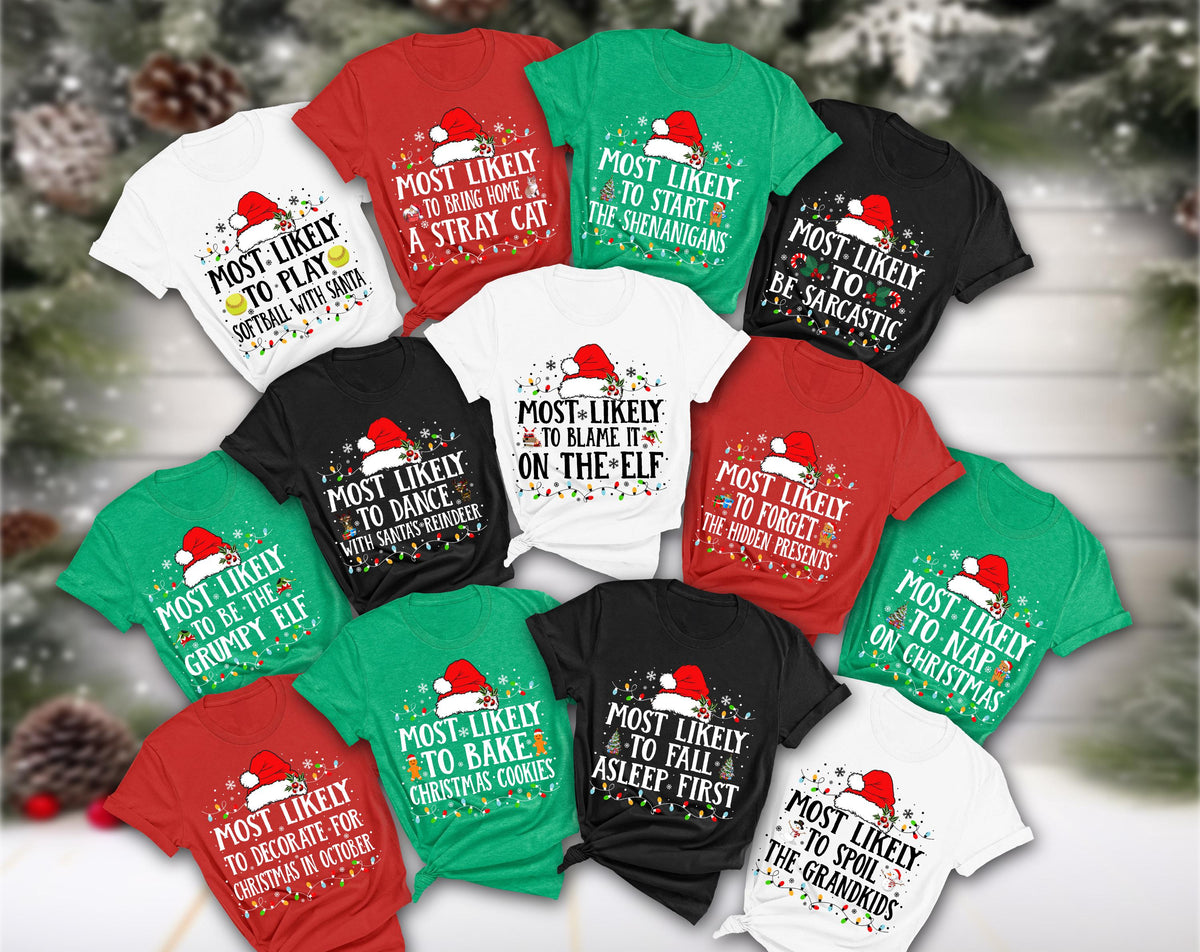 May include: A collection of Christmas-themed t-shirts in various colors, including red, green, black, and white. Each shirt features a Santa hat graphic and a humorous phrase like "Most Likely to Bake Christmas Cookies" or "Most Likely to Blame it on the Elf."