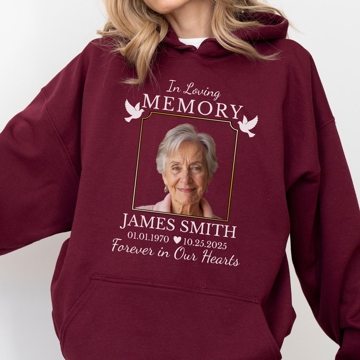 May include: A maroon hooded sweatshirt featuring a memorial graphic with a photograph of an older person. The text reads In Loving MEMORY, JAMES SMITH, 01.01.1970 10.25.2025, and Forever in Our Hearts, accompanied by two white dove illustrations.