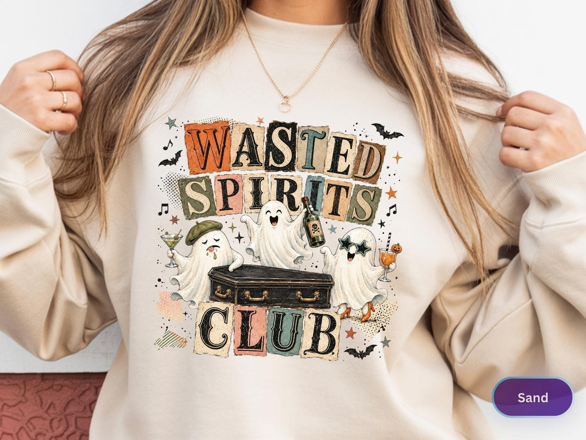 May include: A sand-colored crewneck sweatshirt featuring a graphic print with the text "WASTED SPIRITS CLUB" in block letters. The design includes three white ghosts, a black coffin, bats, stars, and musical notes in various colors.