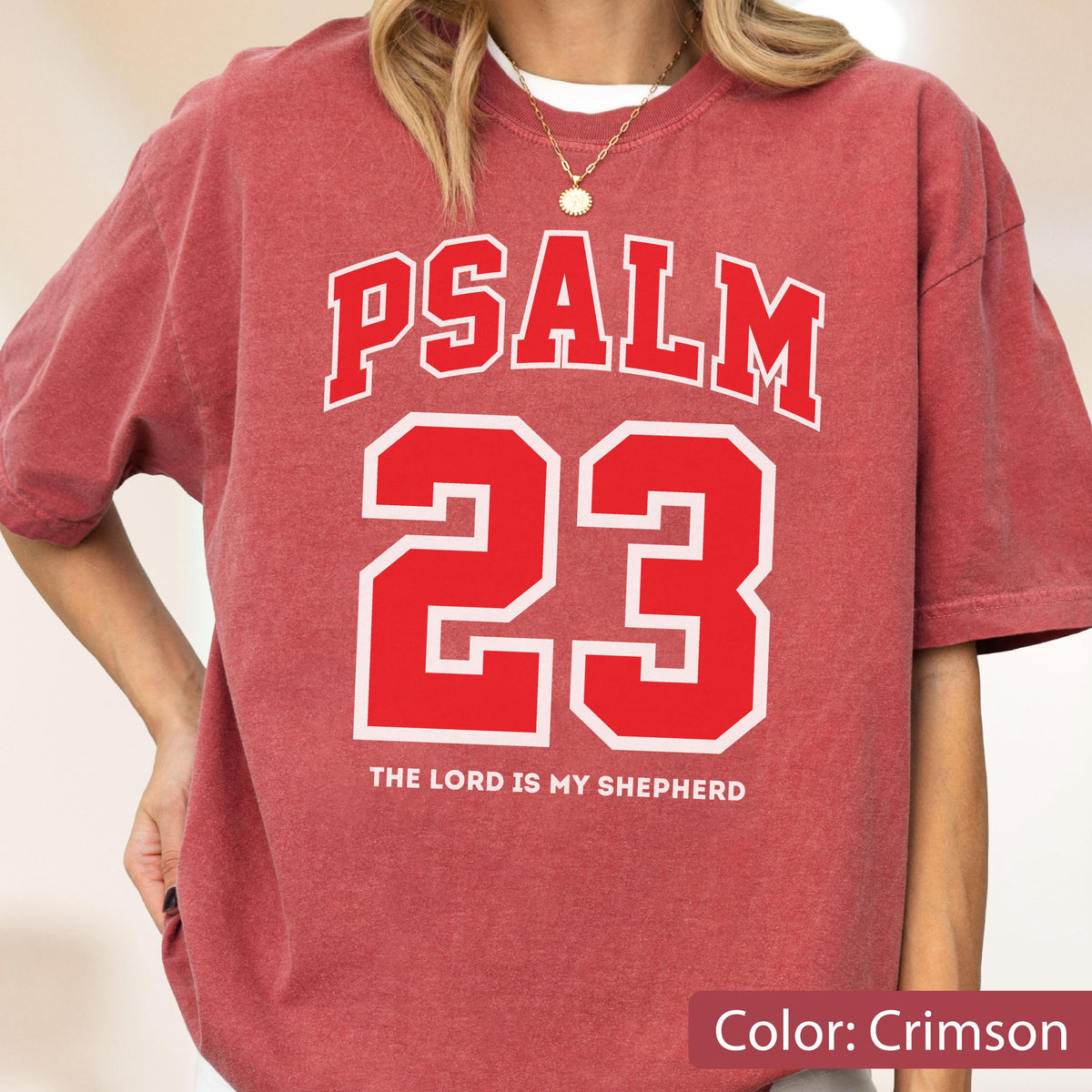 May include: A crimson short-sleeve t-shirt featuring the white text PSALM 23 in a collegiate font, with the number 23 in large red block lettering outlined in white, and the text THE LORD IS MY SHEPHERD printed in white below the number.