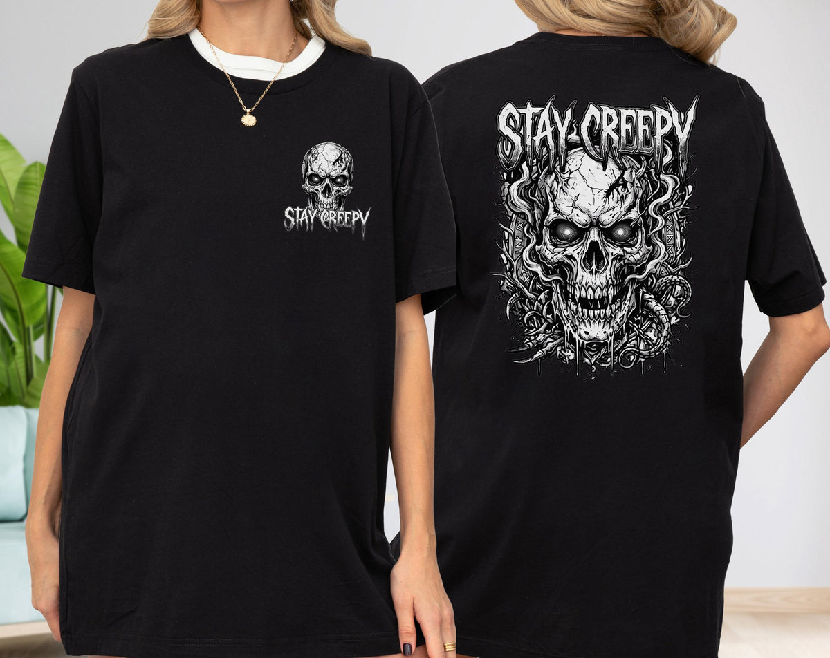 May include: A black short-sleeve t-shirt featuring a small white skull graphic with the text "STAY CREEPY" on the front left chest and a large, detailed white skull illustration with swirling smoke and the text "STAY CREEPY" on the back.