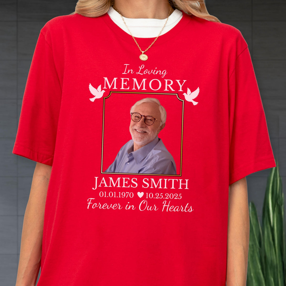 May include: A bright red short-sleeved t-shirt featuring a memorial graphic. The design includes the text In Loving Memory, a photograph of an older person with glasses, the name James Smith, dates 01.01.1970 to 10.25.2025, and white doves.