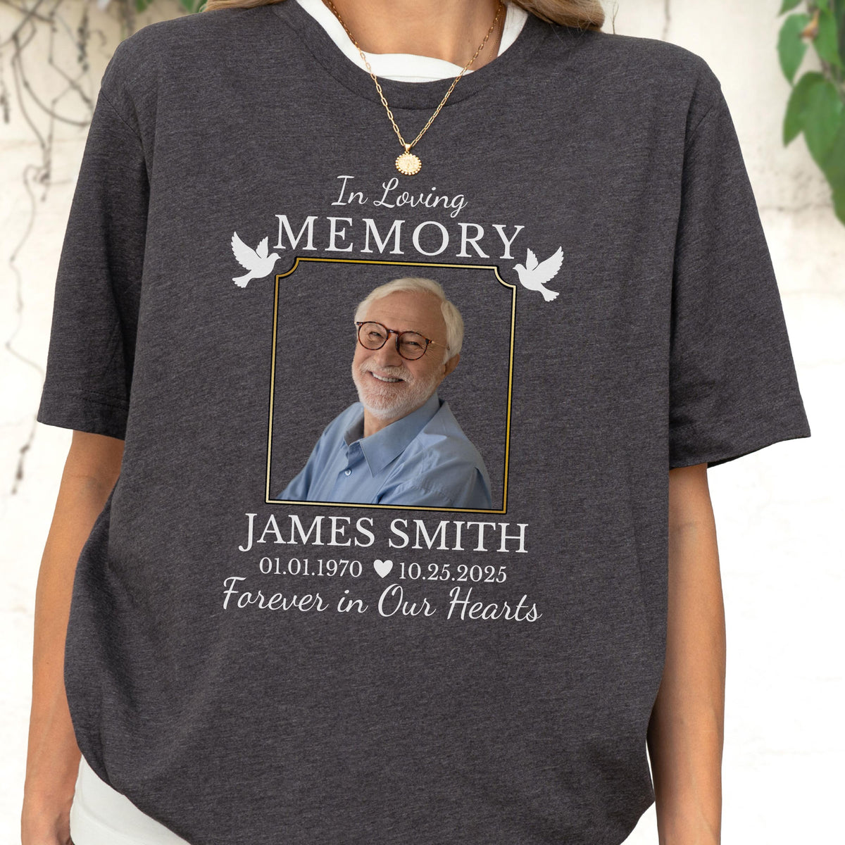 May include: A charcoal gray short-sleeve t-shirt featuring a memorial graphic with the text In Loving Memory, a photograph of a man with glasses, the name James Smith, the dates 01.01.1970 and 10.25.2025, and the phrase Forever in Our Hearts.