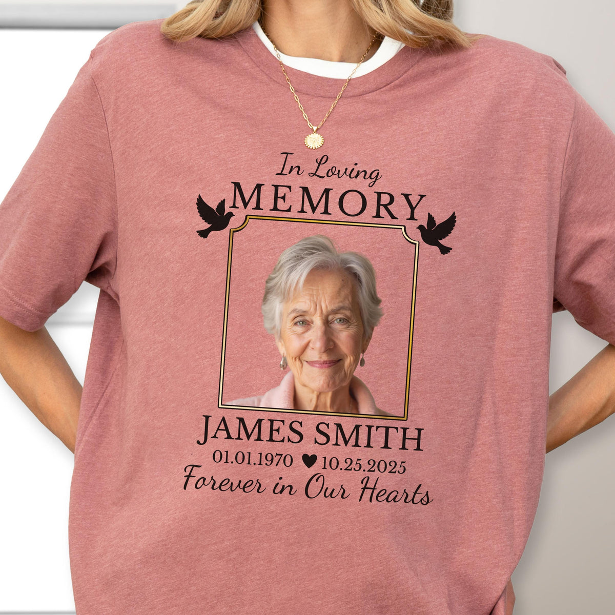 May include: A dusty rose short-sleeve t-shirt featuring a memorial graphic. The design includes the text In Loving Memory, a photograph of an older person, the name JAMES SMITH, dates 01.01.1970 - 10.25.2025, and Forever in Our Hearts.