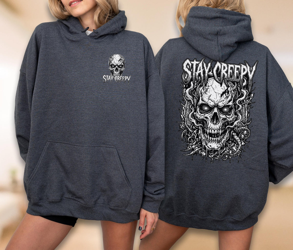 May include: A dark charcoal gray hooded sweatshirt featuring a small white skull graphic and the text STAY CREEPY on the front left chest, with a large, detailed white skull illustration and the text STAY CREEPY printed on the back.