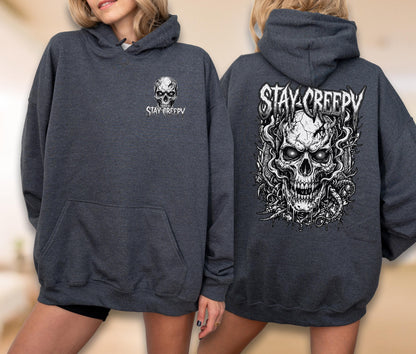 May include: A dark charcoal gray hooded sweatshirt featuring a small white skull graphic and the text STAY CREEPY on the front left chest, with a large, detailed white skull illustration and the text STAY CREEPY printed on the back.