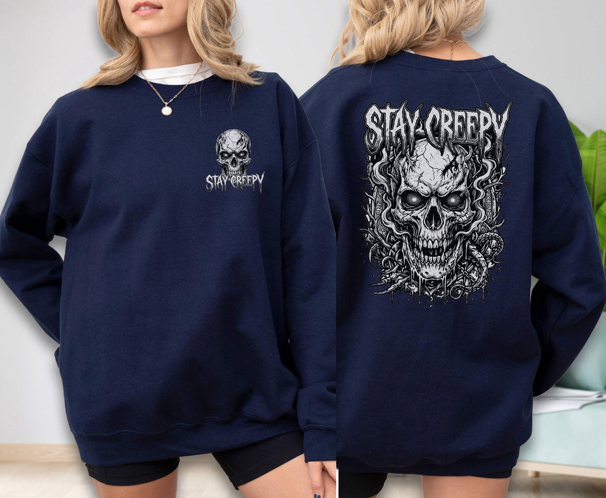 May include: A navy blue long-sleeve sweatshirt featuring a small white skull graphic and the text "STAY CREEPY" on the front left chest, and a large, detailed white skull illustration with the text "STAY CREEPY" printed on the back.