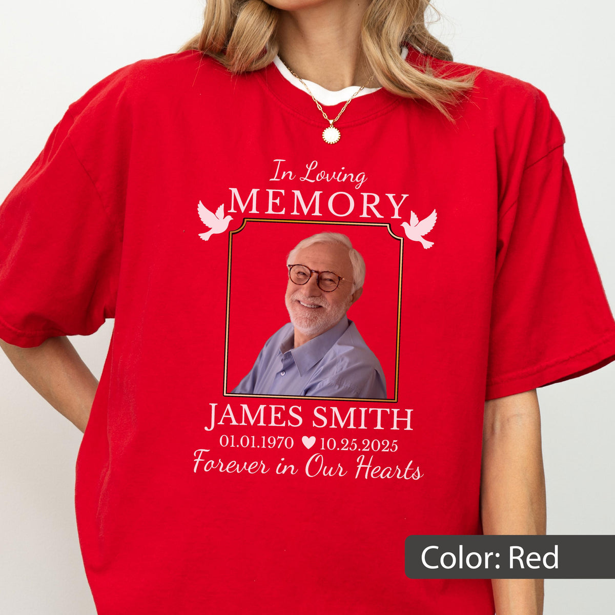 May include: A bright red t-shirt featuring a memorial graphic with the text In Loving Memory, the name James Smith, dates 01.01.1970 - 10.25.2025, and the phrase Forever in Our Hearts. The design includes a photo of a man in glasses and two white doves.