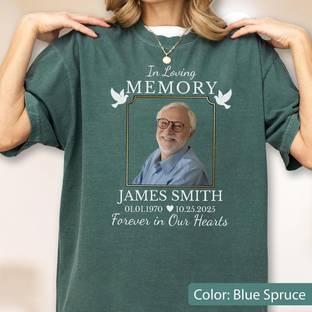 May include: A blue spruce crewneck t-shirt featuring a memorial graphic with the text In Loving Memory, a photograph of a smiling person wearing glasses, the name James Smith, dates 01.01.1970 and 10.25.2025, and the phrase Forever in Our Hearts.