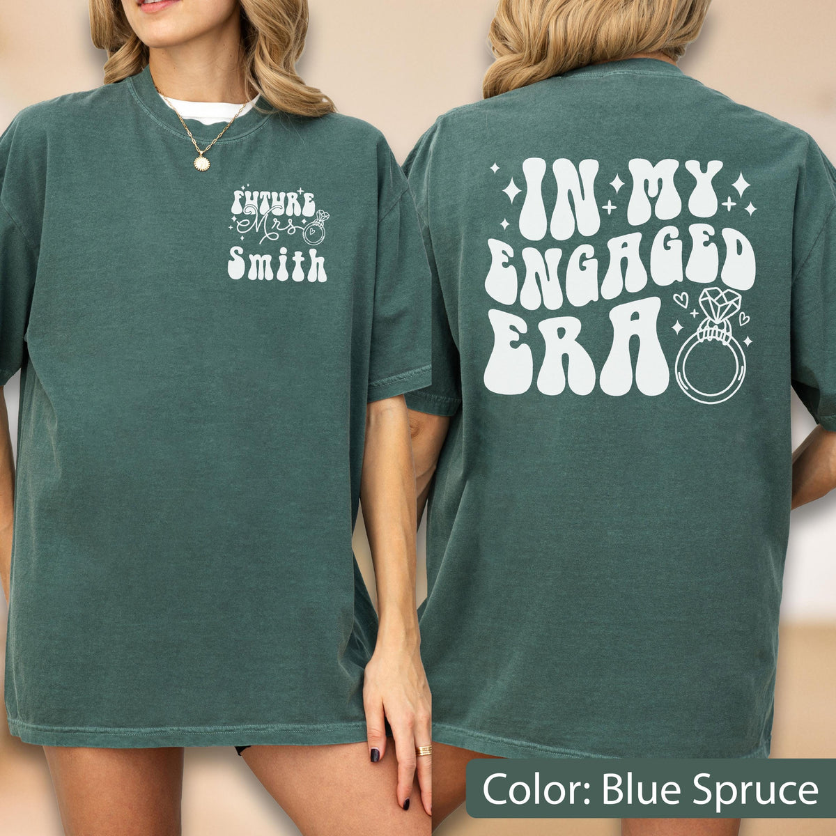 May include: A blue spruce t-shirt featuring white text and graphics. The front displays "Future Mrs. Smith" with a small ring icon. The back features the text "IN MY ENGAGED ERA" in a large, bold, wavy font, accompanied by a diamond ring illustration.