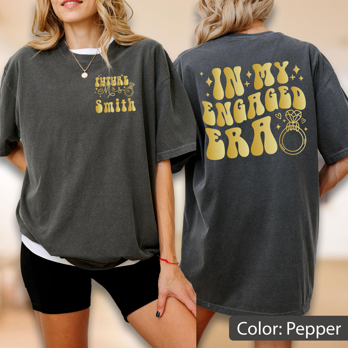 May include: A charcoal gray t-shirt featuring gold text and graphics. The front displays "Future Mrs. Smith" with a small ring icon. The back features the large gold text "IN MY ENGAGED ERA" accompanied by a diamond ring illustration and small stars.