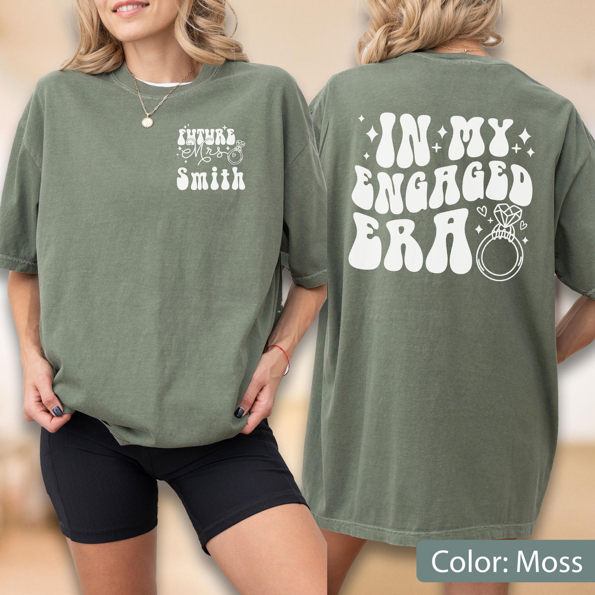 May include: A moss green short-sleeve t-shirt featuring white text. The front displays "FUTURE MRS SMITH" with a small ring icon. The back features the large white text "IN MY ENGAGED ERA" accompanied by a diamond ring graphic and small star accents.