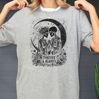 May include: A heather gray t-shirt featuring a black graphic print of two skeletons holding hands under a crescent moon. The design includes floral accents and the text "FOREVER & ALWAYS" centered below the figures in a decorative serif font.