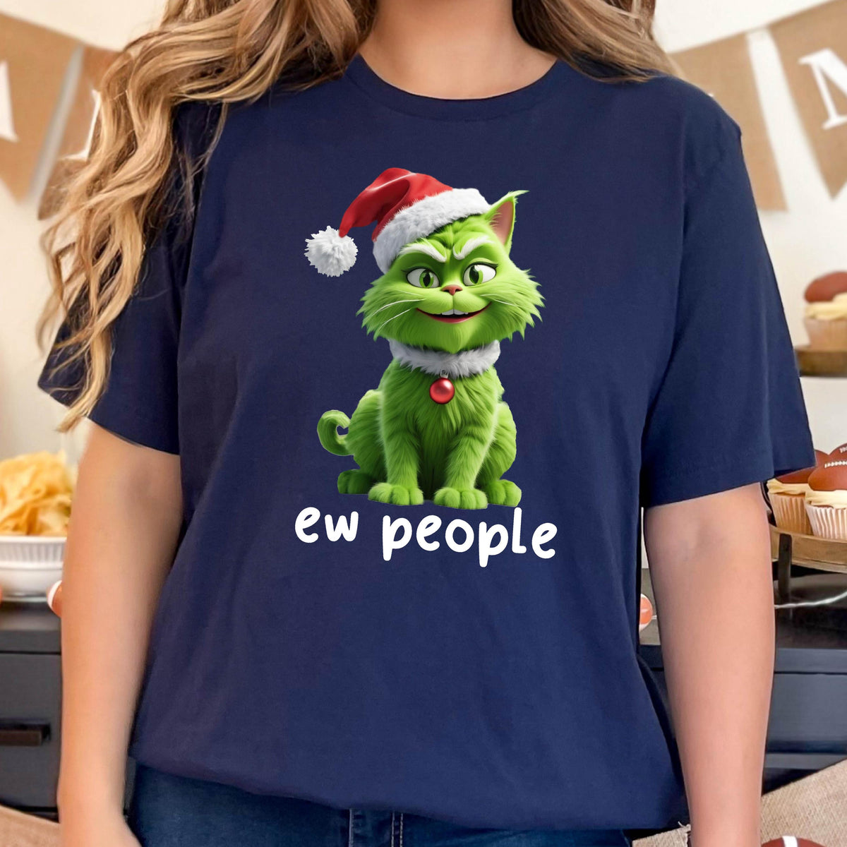 May include: Navy blue t-shirt featuring a green cat wearing a Santa hat and a white collar. The cat has a mischievous grin and the text "ew people" is printed below the cat in white.