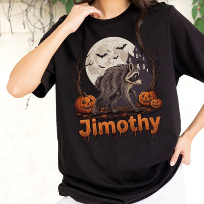 May include: A black t-shirt featuring a graphic of a raccoon standing in front of a full moon, bare trees, and a haunted house. Three orange jack-o'-lanterns are on the ground with bats flying above. The name Jimothy is printed in orange.