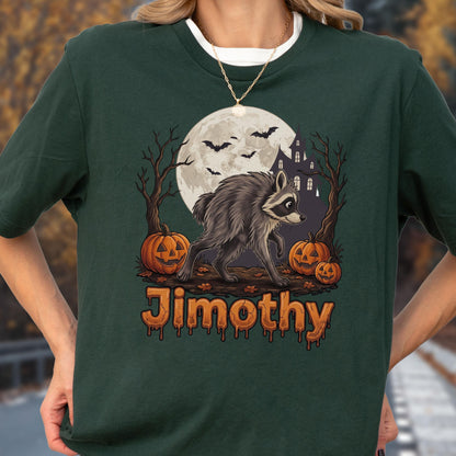 May include: A dark green t-shirt featuring a graphic of a raccoon, a full moon, bats, a haunted house, and jack-o'-lanterns. The name Jimothy is printed in orange, dripping-style lettering at the bottom of the graphic design on the front.