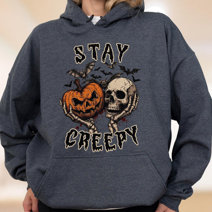 May include: A dark heather gray hooded sweatshirt featuring a graphic print of a jack-o'-lantern and a human skull held by skeletal hands. Above and below the illustration, the text reads STAY CREEPY in a stylized, dripping black font.