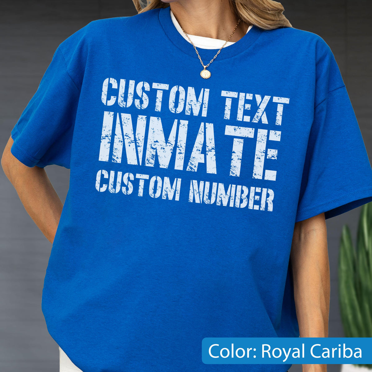 May include: A royal blue short-sleeved t-shirt featuring white distressed-style text on the front. The text reads CUSTOM TEXT, INMATE, and CUSTOM NUMBER in a bold, block-letter font. The shirt has a crew neckline and a relaxed, loose-fitting cut.