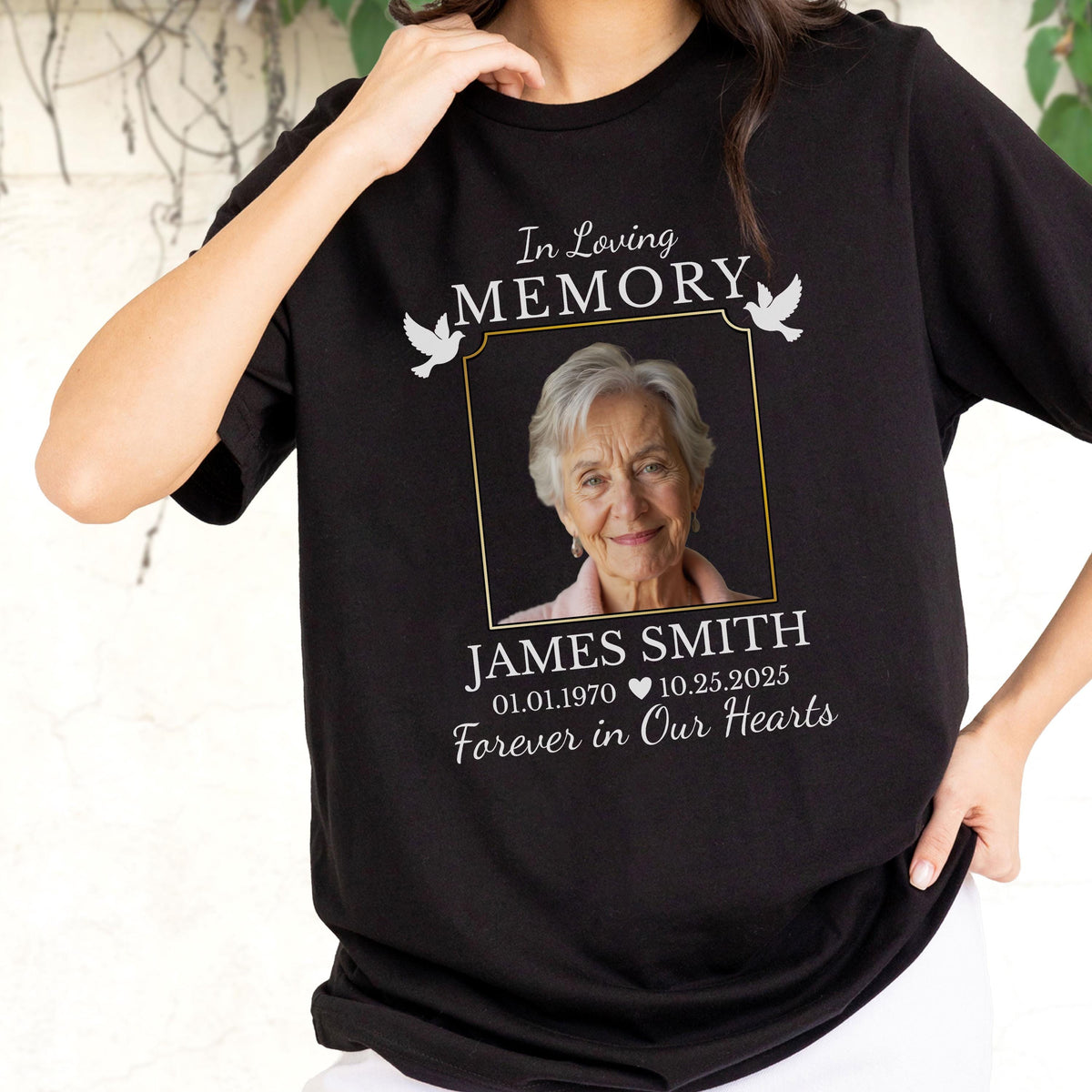 May include: A black short-sleeve t-shirt featuring a memorial graphic with the text In Loving Memory, a photograph of an older person, the name JAMES SMITH, the dates 01.01.1970 and 10.25.2025, and the phrase Forever in Our Hearts.