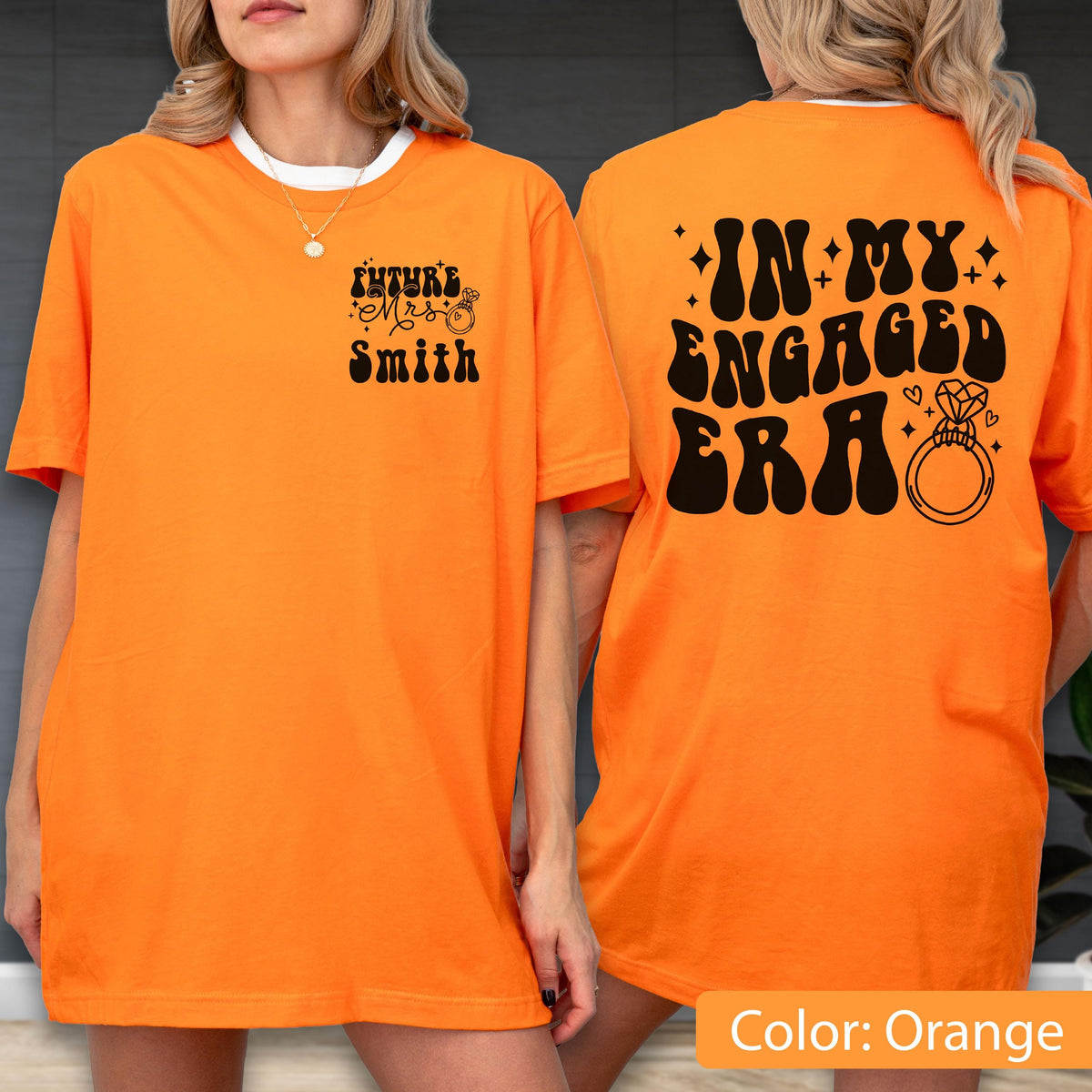 May include: An orange t-shirt featuring black text and graphics. The front displays "FUTURE MRS SMITH" with a small ring icon. The back features the large text "IN MY ENGAGED ERA" accompanied by star accents and a prominent diamond ring illustration.