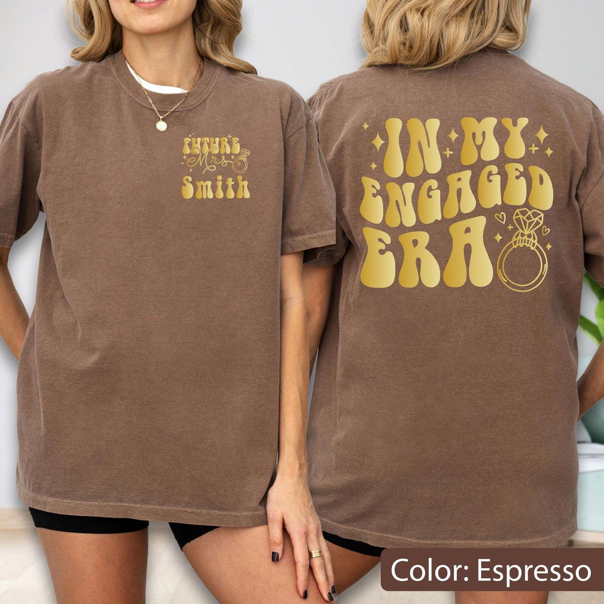 May include: An espresso brown t-shirt featuring gold text. The front left chest displays "Future Mrs. Smith" with a small ring icon. The back features large gold text reading "IN MY ENGAGED ERA" accompanied by a diamond ring graphic and small stars.