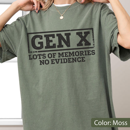 May include: A moss green short-sleeve t-shirt featuring a black rectangular graphic with the text "GEN X" at the top and the phrase "LOTS OF MEMORIES NO EVIDENCE" printed in bold, distressed capital letters underneath the main heading.