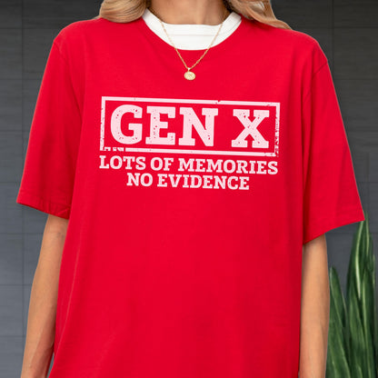 May include: A bright red short-sleeved t-shirt featuring a white rectangular graphic with the distressed text "GEN X" at the top and "LOTS OF MEMORIES NO EVIDENCE" underneath. The shirt is worn over a white crew neck base layer with a gold chain necklace.