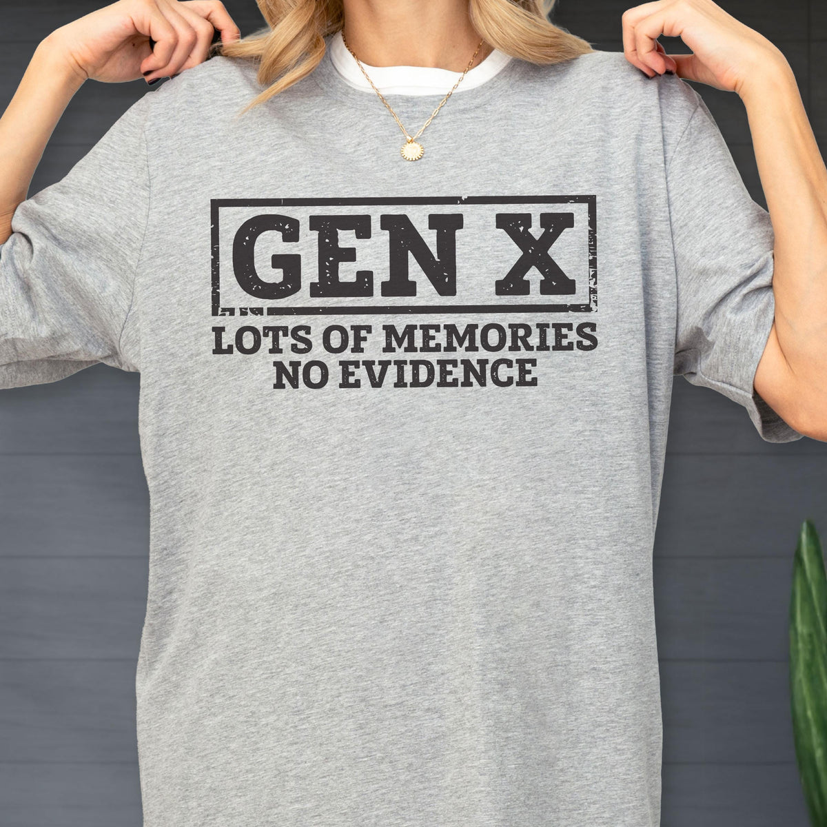May include: A heather gray short-sleeve t-shirt featuring a black rectangular border containing the text GEN X in a bold, distressed font, followed by the text LOTS OF MEMORIES NO EVIDENCE in a matching black, distressed, sans-serif typeface.