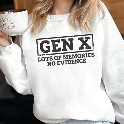 May include: A white crewneck sweatshirt featuring a black graphic print that reads GEN X in a rectangular border, with the text LOTS OF MEMORIES NO EVIDENCE underneath. The design has a distressed, weathered texture throughout the lettering.