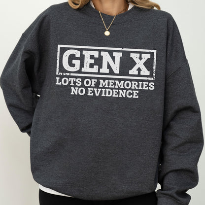 May include: A dark charcoal gray crewneck sweatshirt featuring white distressed-style text that reads GEN X LOTS OF MEMORIES NO EVIDENCE enclosed within a rectangular border. The garment has long sleeves and a ribbed neckline.