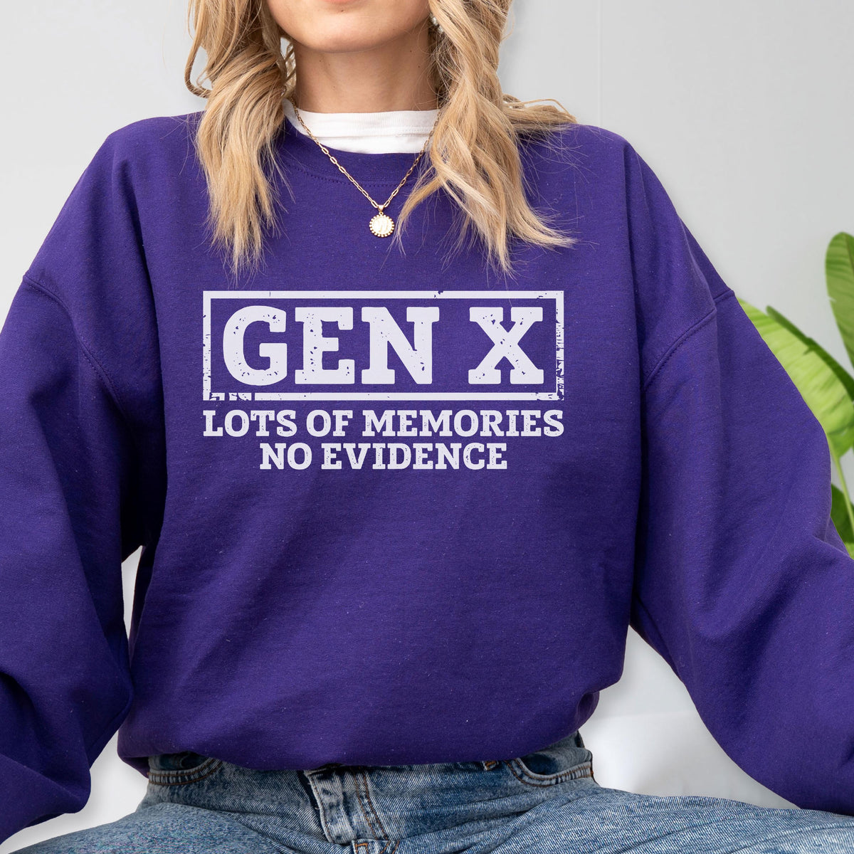 May include: A deep purple long-sleeve crewneck sweatshirt featuring a white rectangular graphic with the text GEN X LOTS OF MEMORIES NO EVIDENCE. The text is printed in a bold, distressed font style centered on the chest of the garment.
