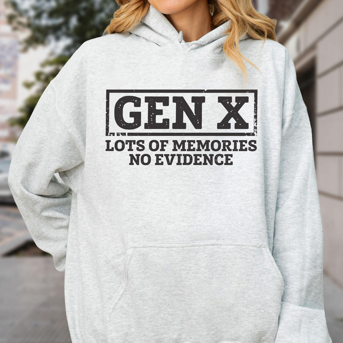 May include: A light gray hooded sweatshirt featuring a black rectangular graphic with the text GEN X in a bold, distressed font, followed by the text LOTS OF MEMORIES NO EVIDENCE in a matching black, sans-serif, distressed typeface.