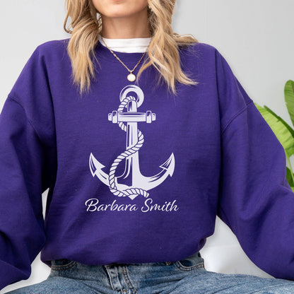 May include: A deep purple long-sleeve crewneck sweatshirt featuring a large white graphic of a nautical anchor wrapped in rope. The text "Barbara Smith" is printed in a white script font directly below the anchor design on the front.