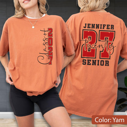 May include: A yam-colored t-shirt featuring black and red text. The front displays vertical text reading Class of 2027. The back features the name Jennifer above the large red number 27, with the word twenty in script and the word SENIOR below.