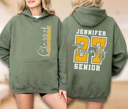 May include: An olive green hooded sweatshirt featuring a front graphic with the text Class of 2027 in white and yellow. The back displays the name Jennifer above a large yellow number 27, the word Twenty in white script, and the word Senior below.