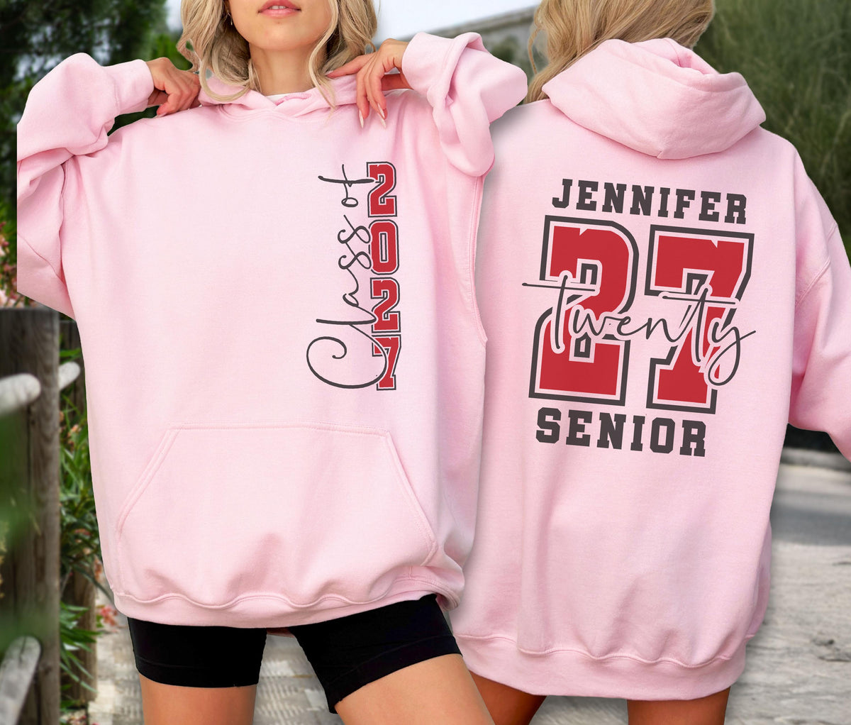 May include: A light pink hooded sweatshirt featuring a front graphic with the vertical text Class of 2027 in black and red. The back displays the name Jennifer above the large red number 27, the word twenty in script, and the word SENIOR in black.