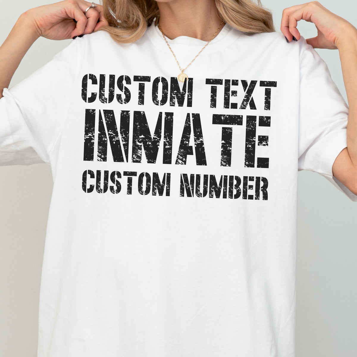 May include: A white short-sleeved t-shirt featuring black distressed-style text printed on the front. The text reads CUSTOM TEXT, INMATE, and CUSTOM NUMBER in a bold, blocky font. The design has a weathered, worn-in appearance across the chest.