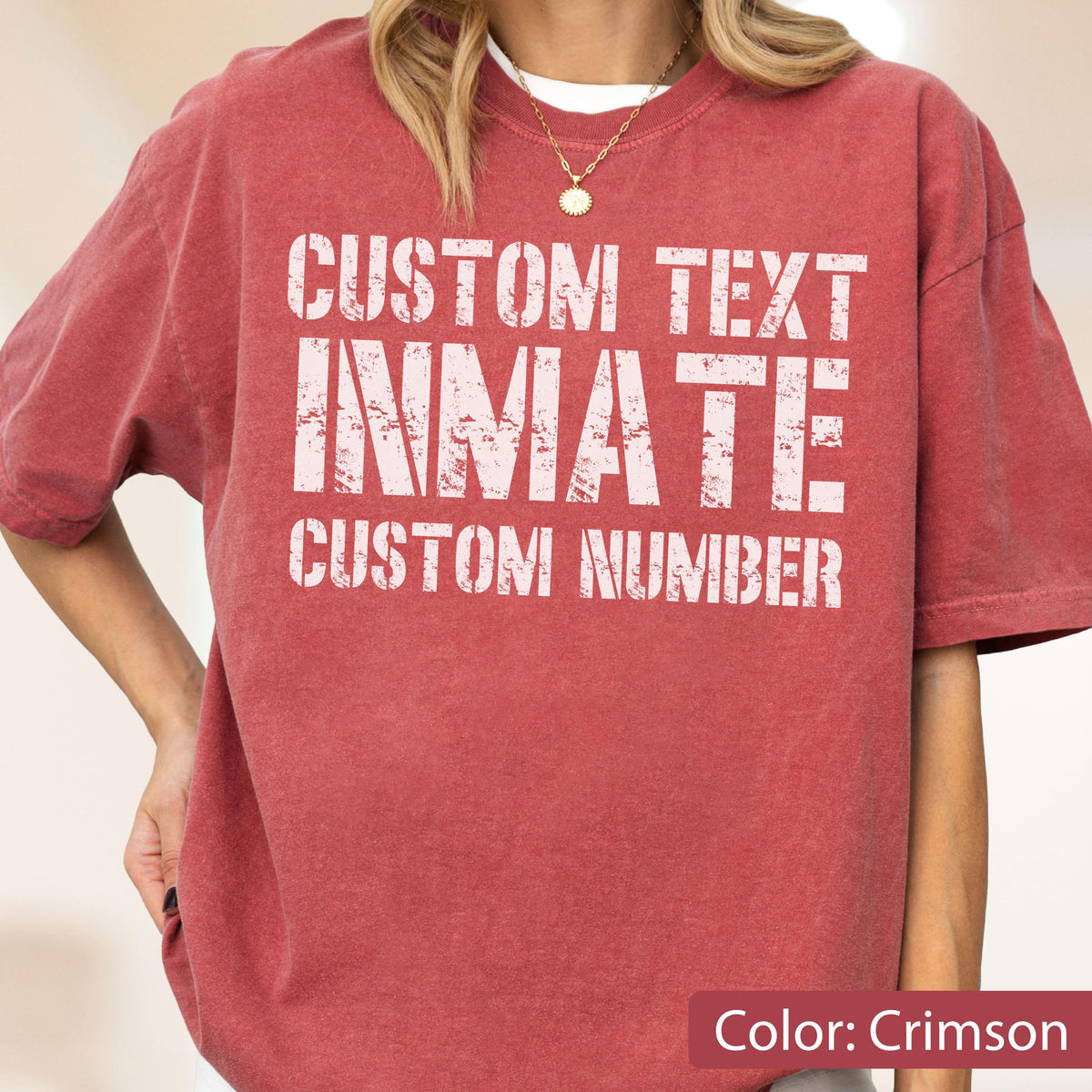 May include: A crimson short-sleeved t-shirt featuring white distressed-style text on the front. The text reads CUSTOM TEXT, INMATE, and CUSTOM NUMBER in a bold, block-letter font. The shirt has a crew neckline and a relaxed, loose-fitting silhouette.